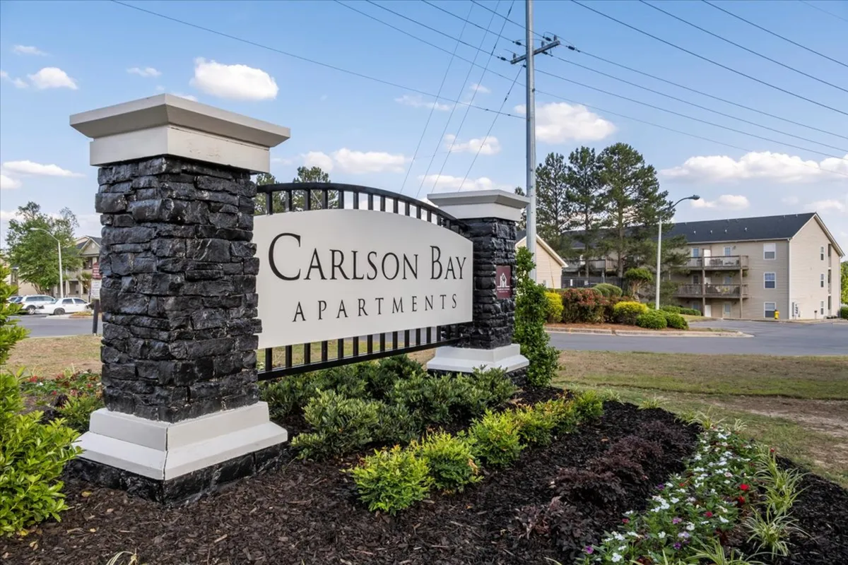 This exterior shot showcases the inviting entrance to the building, with clear signage and a beautifully landscaped garden setting the stage for the property's welcoming atmosphere. The image hints at a vibrant community vibe with space for gatherings and social events.